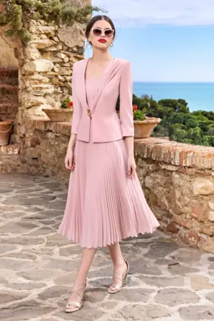 Blush pink sleeveless pleated midi dress with square neckline by Sonia Pena, worn outdoors in a Mediterranean setting