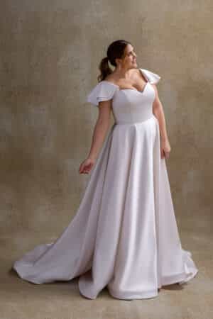 Plus size bride wearing Chloe satin gown with flutter sleeves and circular skirt, Curvy Chic Bridal