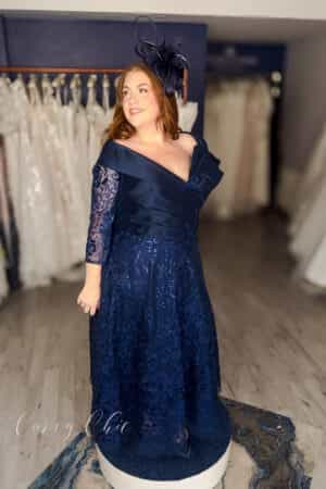 Plus size model wearing navy Bardot lace midi dress by Veni Infantino at Curvy Chic Bridal 992532