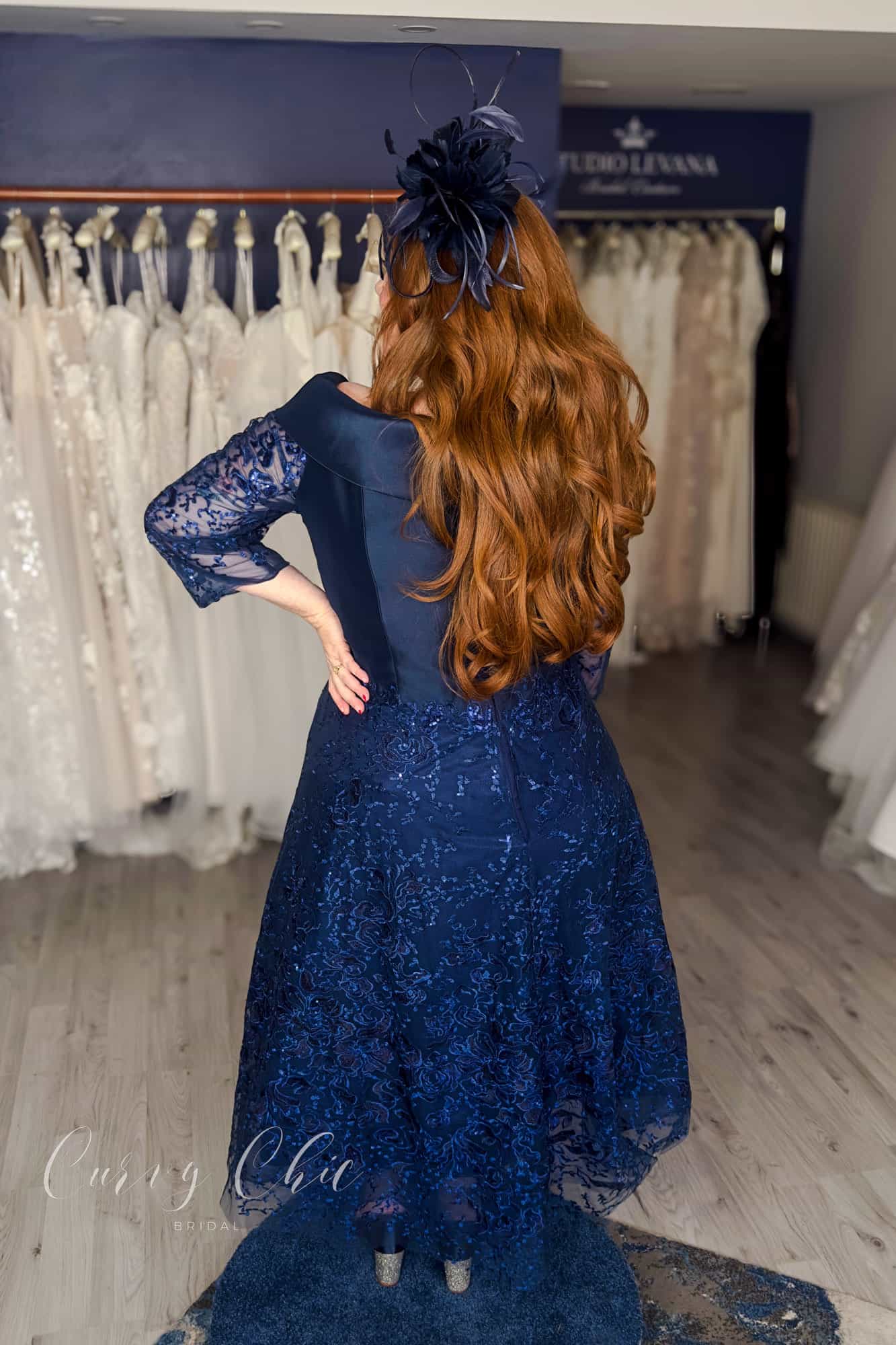 Plus size model wearing navy Bardot lace midi dress by Veni Infantino at Curvy Chic Bridal 992532 back view